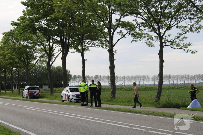 Personenauto raakt te water naast doorgaande weg