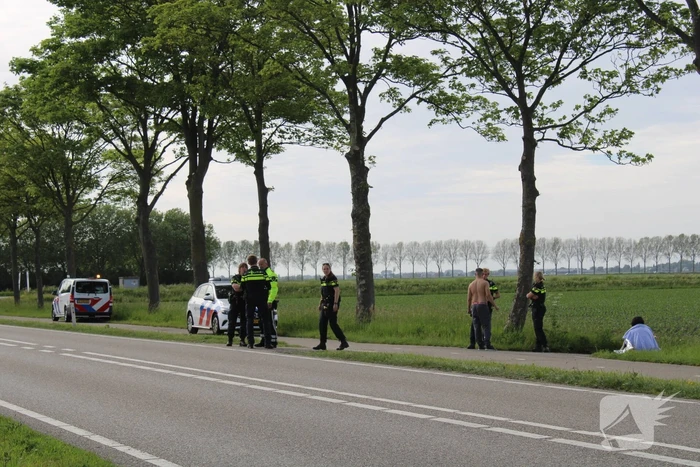 Personenauto raakt te water naast doorgaande weg