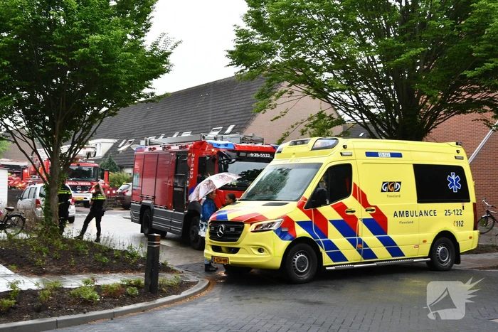 Veel rook uit zolderraam bij brand in woning
