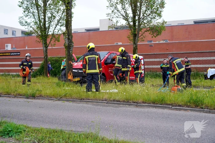 Bestuurder bestelbus bekneld na botsing tegen boom
