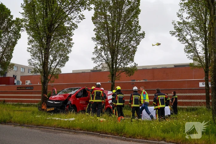 Bestuurder bestelbus bekneld na botsing tegen boom