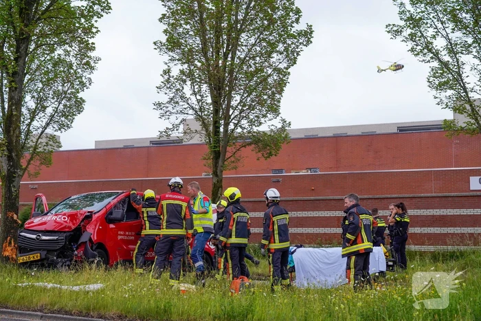 Bestuurder bestelbus bekneld na botsing tegen boom