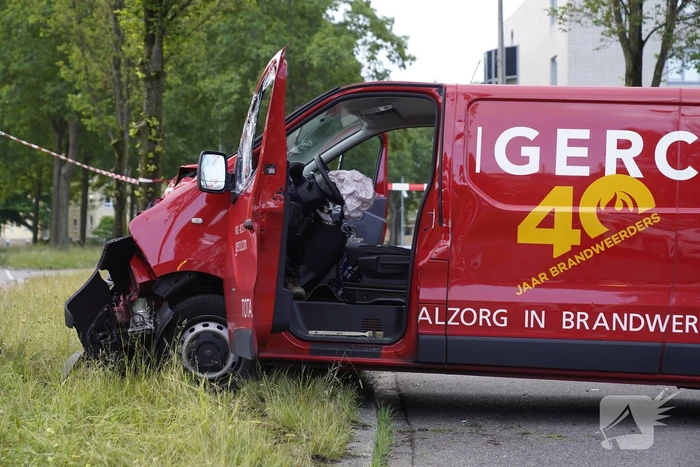 Bestuurder bestelbus bekneld na botsing tegen boom