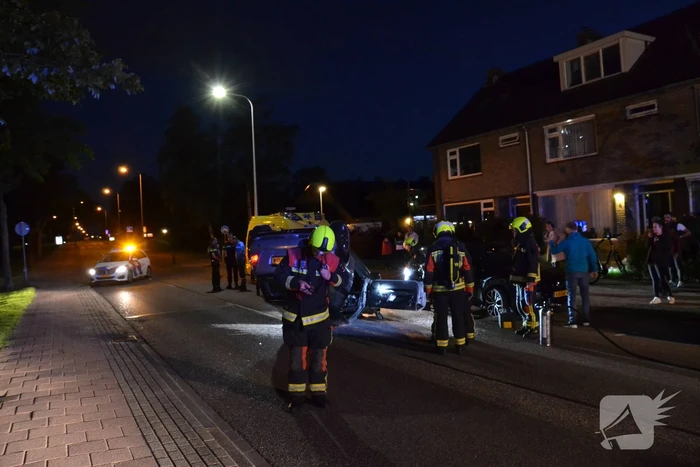 Auto op zijn kop na botsing met geparkeerde auto