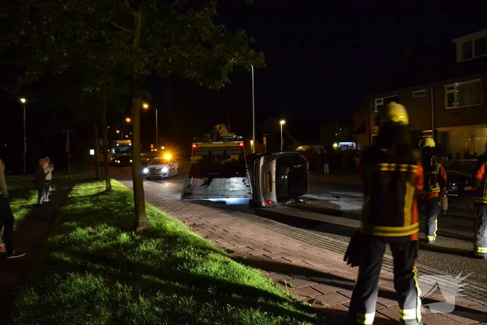 Auto op zijn kop na botsing met geparkeerde auto