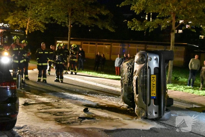 Auto op zijn kop na botsing met geparkeerde auto