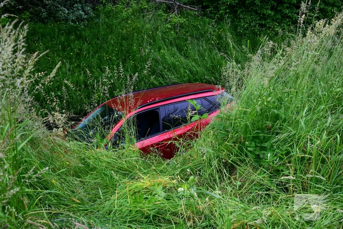 Auto rijdt over rotonde de sloot in