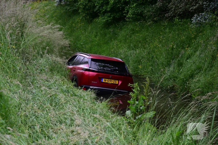 Auto rijdt over rotonde de sloot in