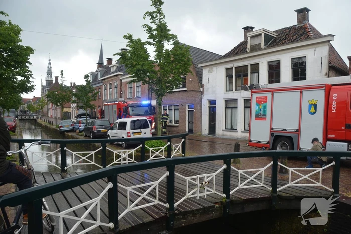 Auto bengelt op rand van gracht