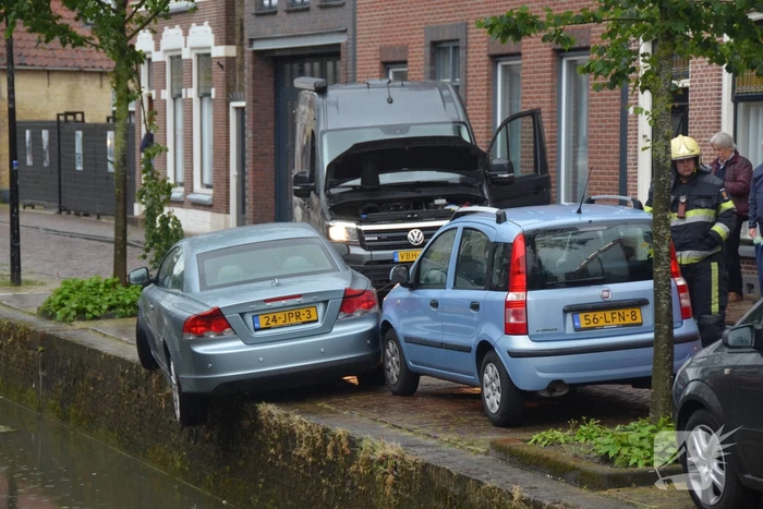Auto bengelt op rand van gracht