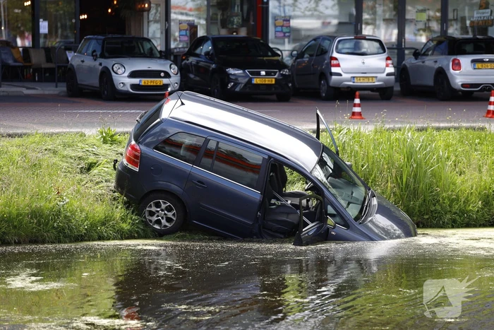 Geparkeerde auto belandt half in het water