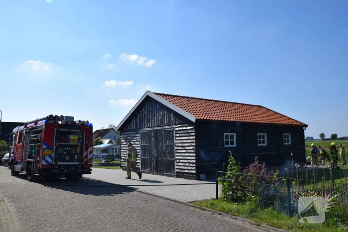 Houten balken achter schuur vlam gevat