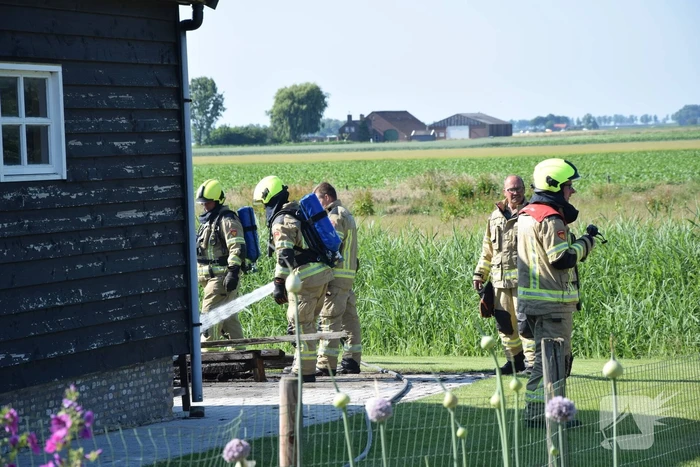 Houten balken achter schuur vlam gevat