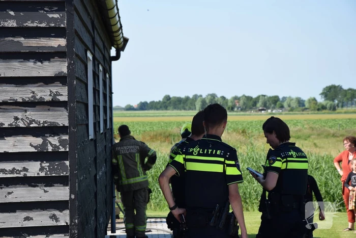 Houten balken achter schuur vlam gevat