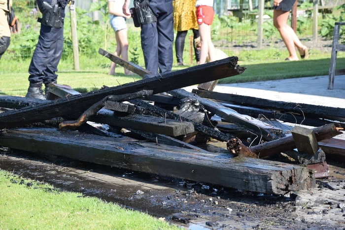 Houten balken achter schuur vlam gevat