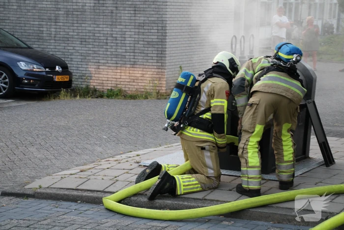 Brandweer blust brandende container