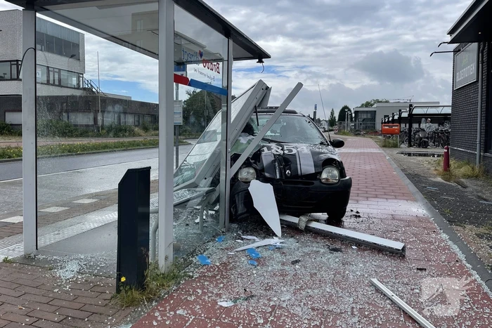 Auto crasht dwars door bushokje heen