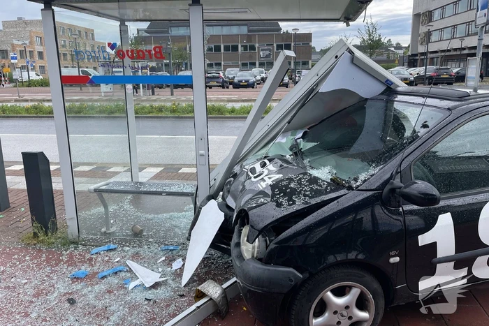 Auto crasht dwars door bushokje heen