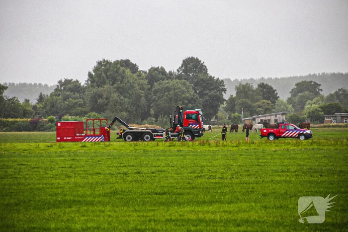 Paard met kraan uit sloot getakeld