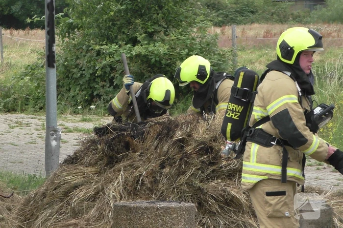 Brandweer blust brandende hooibaal