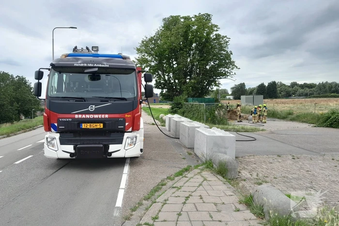 Brandweer blust brandende hooibaal