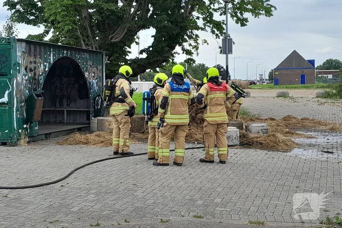Brandweer blust brandende hooibaal