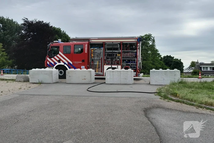 Brandweer blust brandende hooibaal
