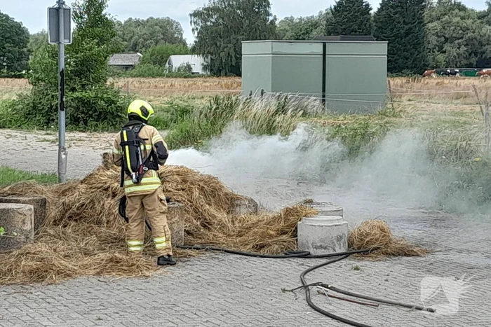 Brandweer blust brandende hooibaal