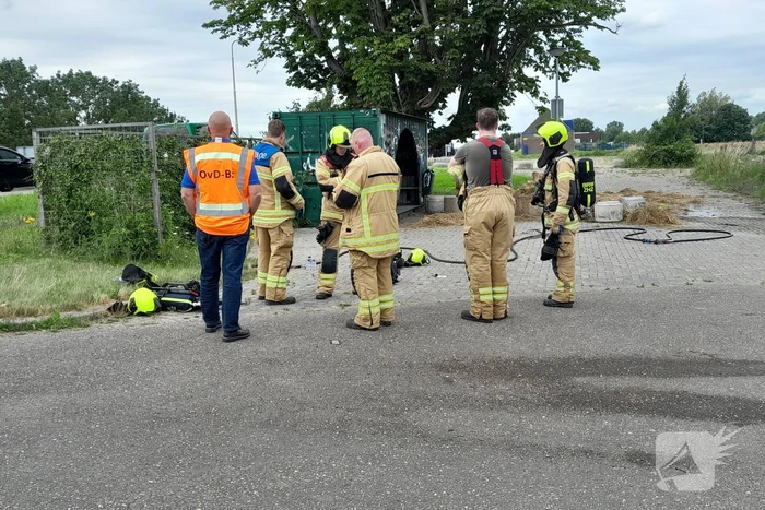 Brandweer blust brandende hooibaal