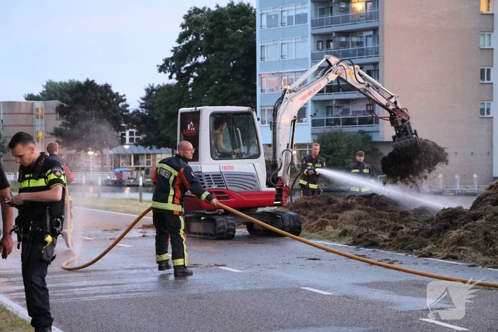 Stapel hooi langs de weg in brand gestoken