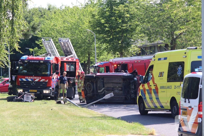 Auto op de kant na botsing met lantaarnpaal