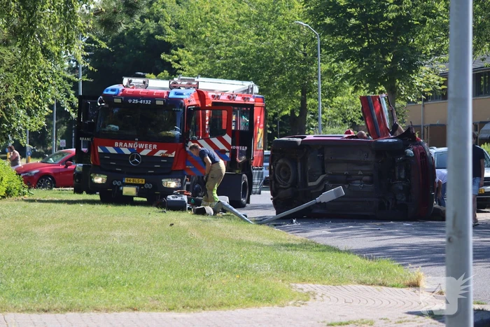Auto op de kant na botsing met lantaarnpaal