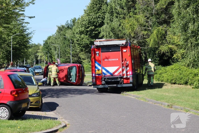 Auto op de kant na botsing met lantaarnpaal