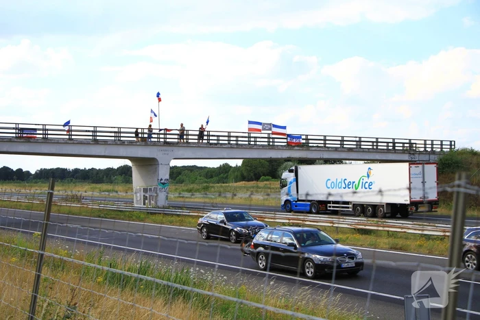 Actievoerders met omgekeerde vlaggen op viaduct van A2