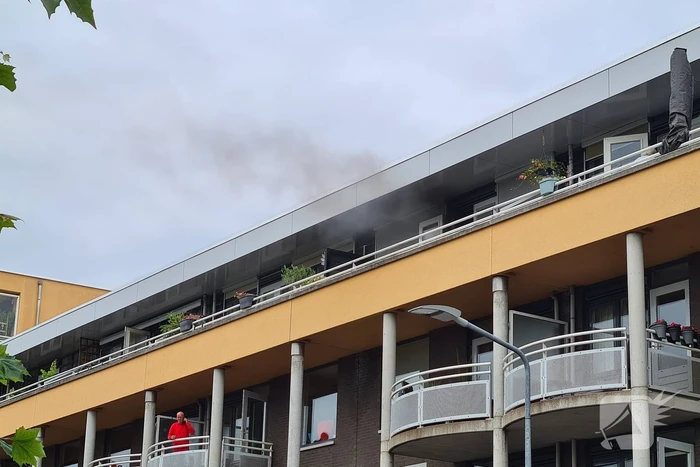 Zwarte rook uit appartement vanwege brand