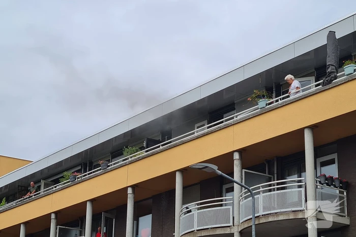 Zwarte rook uit appartement vanwege brand