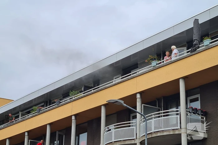 Zwarte rook uit appartement vanwege brand