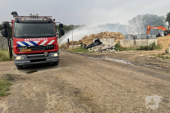 Grote berg met hooibalen in brand