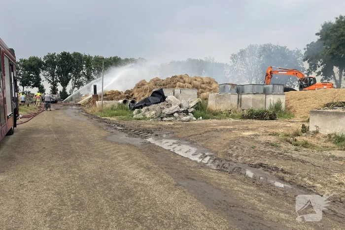 Grote berg met hooibalen in brand