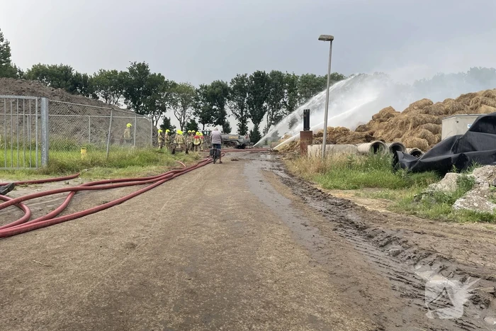 Grote berg met hooibalen in brand