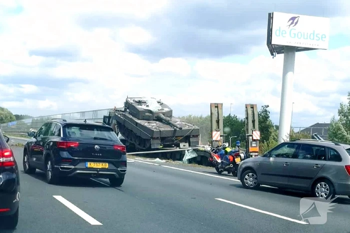 Vrachtwagen met gevechtstank boort zich in geluidswal