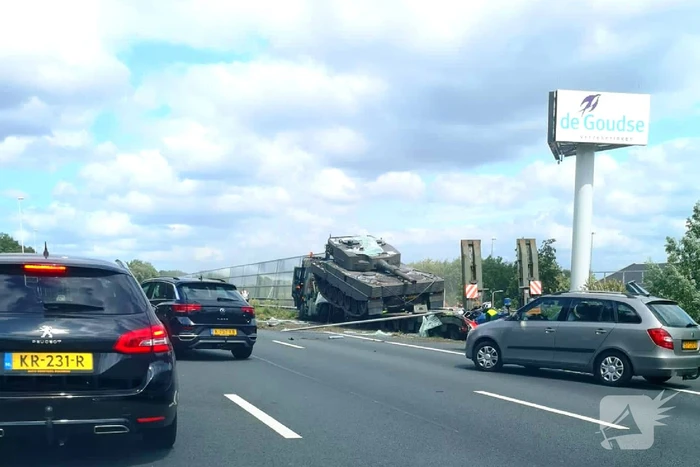 Vrachtwagen met gevechtstank boort zich in geluidswal
