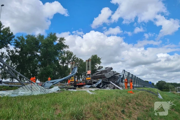 Vrachtwagen met gevechtstank boort zich in geluidswal