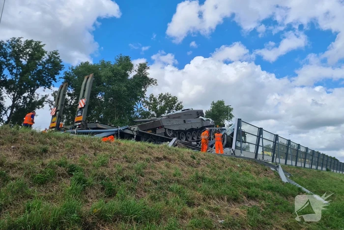 Vrachtwagen met gevechtstank boort zich in geluidswal