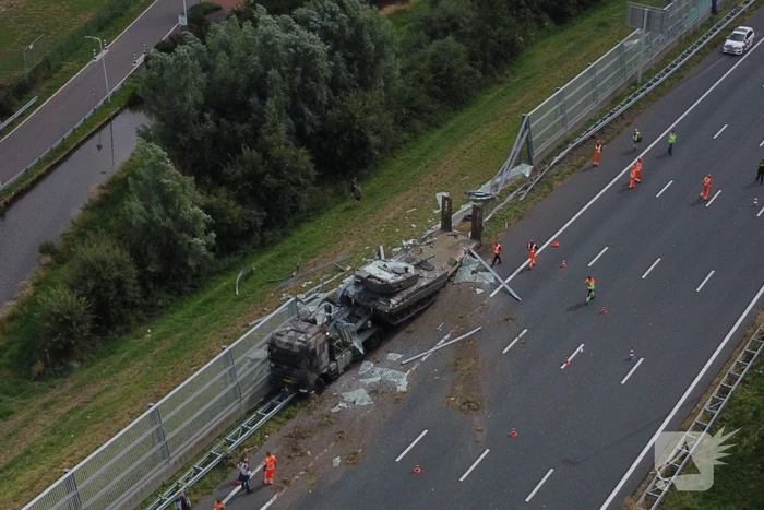 Vrachtwagen met gevechtstank boort zich in geluidswal