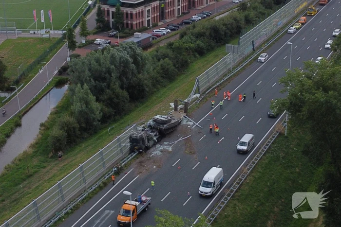 Vrachtwagen met gevechtstank boort zich in geluidswal