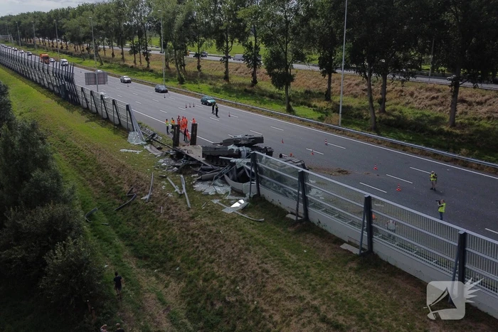 Vrachtwagen met gevechtstank boort zich in geluidswal