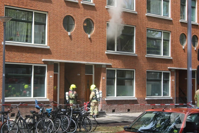 Veel rookontwikkeling vanwege brand in portiekwoning