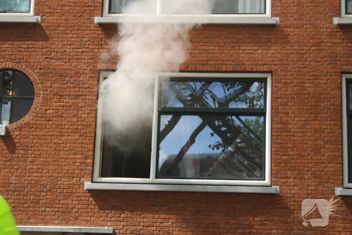 Veel rookontwikkeling vanwege brand in portiekwoning