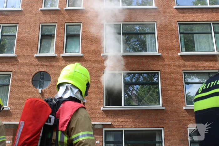 Veel rookontwikkeling vanwege brand in portiekwoning